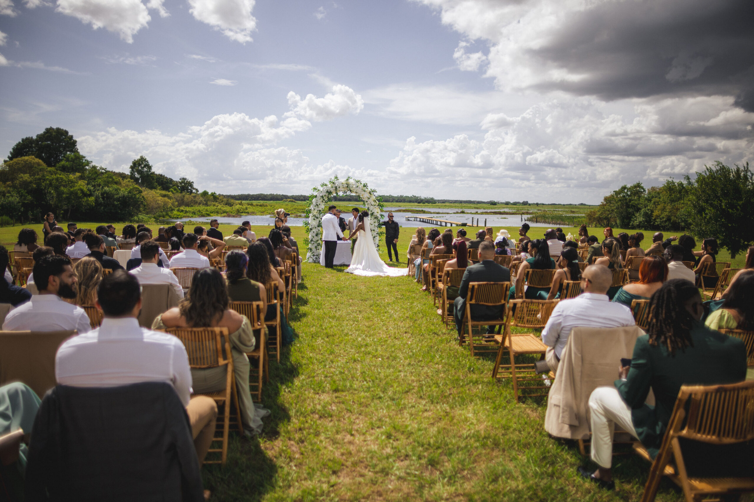 outside Florida wedding ceremony, lakeside, couple exchanging vows