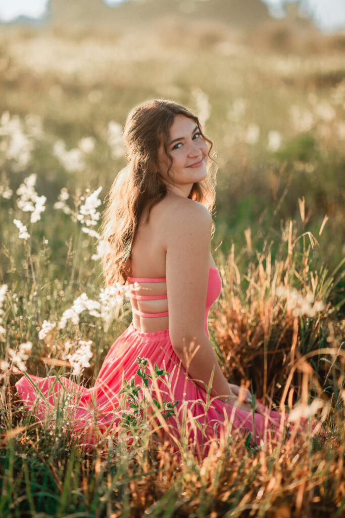 bridesmaid sitting in Florida wildflowers at wedding venue in Orlando