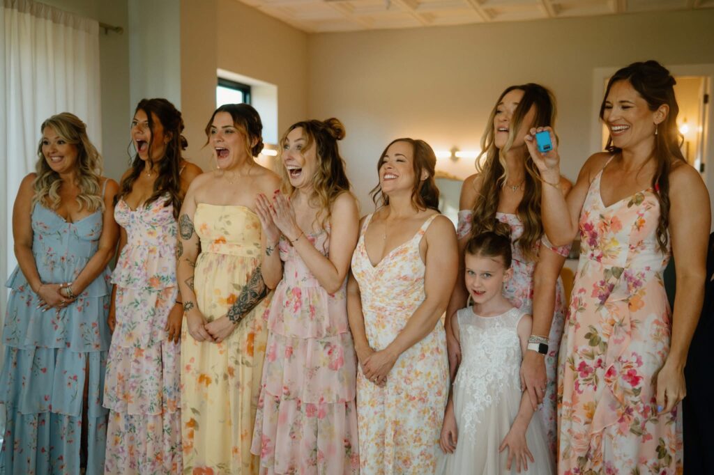 Bridesmaids seeing the bride for the first time in her dress, floral mismatched wedding trends
