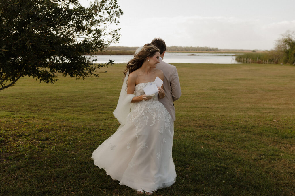 bride and groom sharing private vows prior to wedding ceremony at lakefront wedding venue