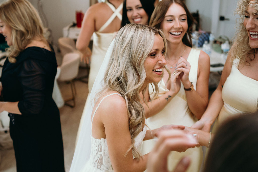 bride with her bridesmaids in bridal suite at lakeside luxury barn wedding venue