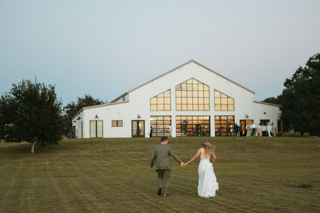 bride and groom walking back to the venue during cocktail hour prior to wedding reception