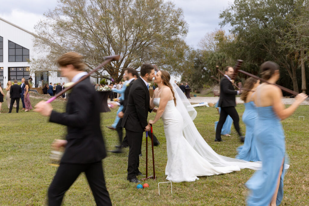 bride and groom playing a match of croquet during cocktail hour at their wedding at lakeside Florida’s venue