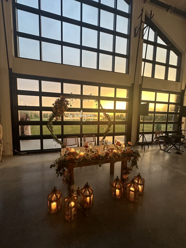 Beautiful neon sign behind the sweetheart table for a wedding. Garage doors with a view to the sunset on Lake Toho