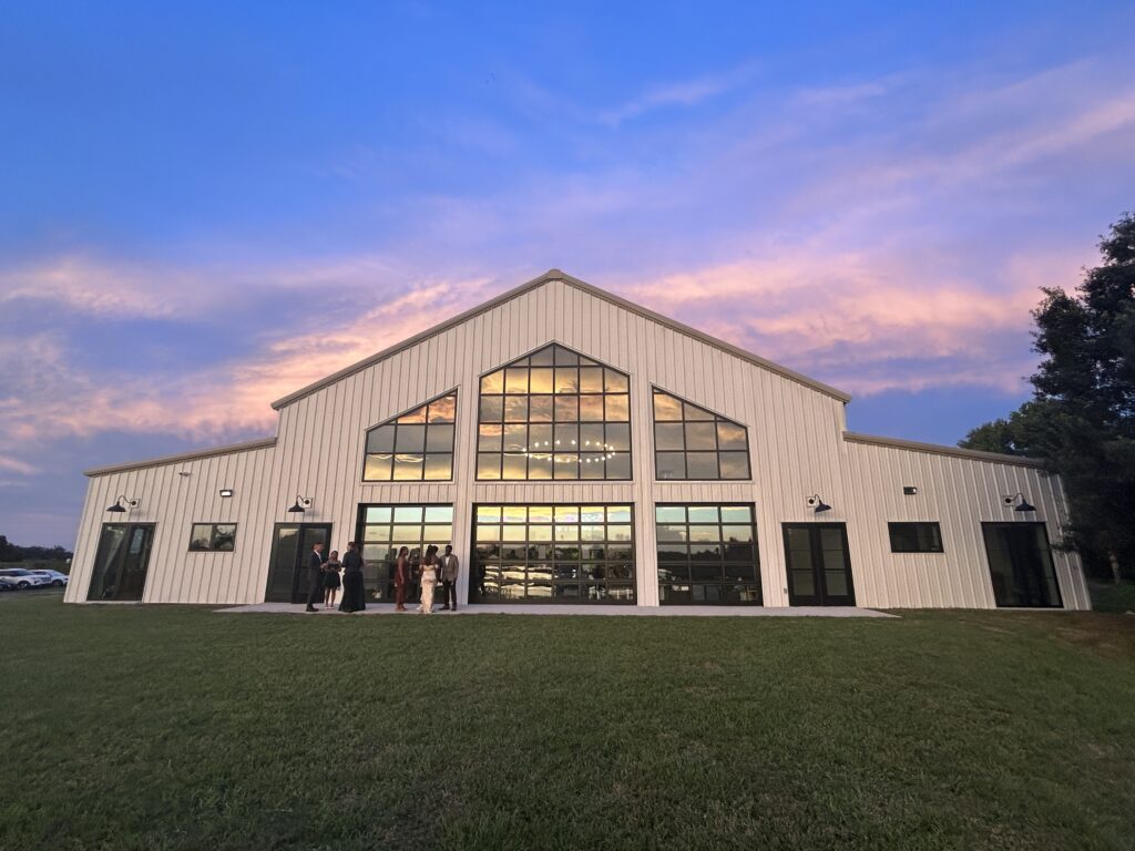 Florida sunset reflecting from the lake to the luxury barn during wedding reception