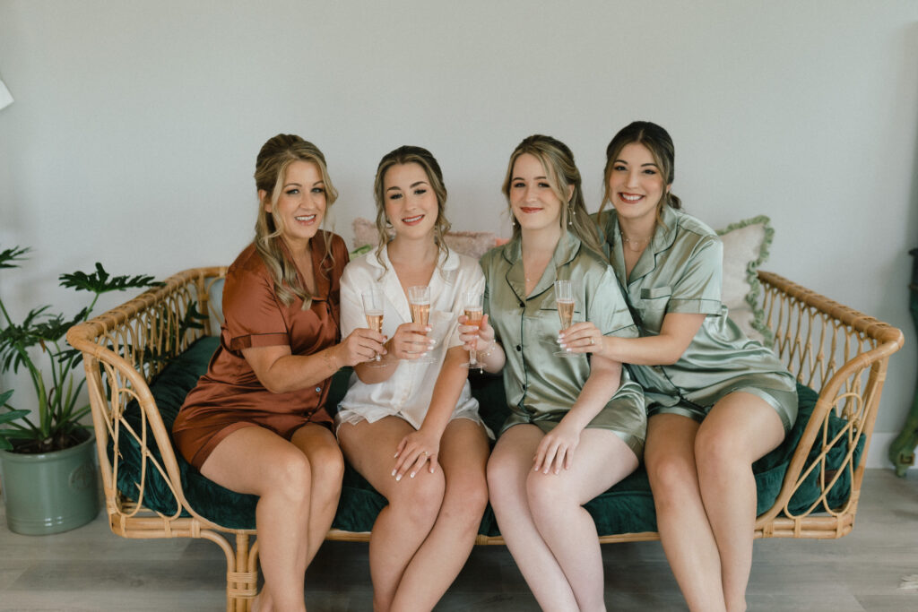 girls getting ready for wedding with champagne in bridal suite
