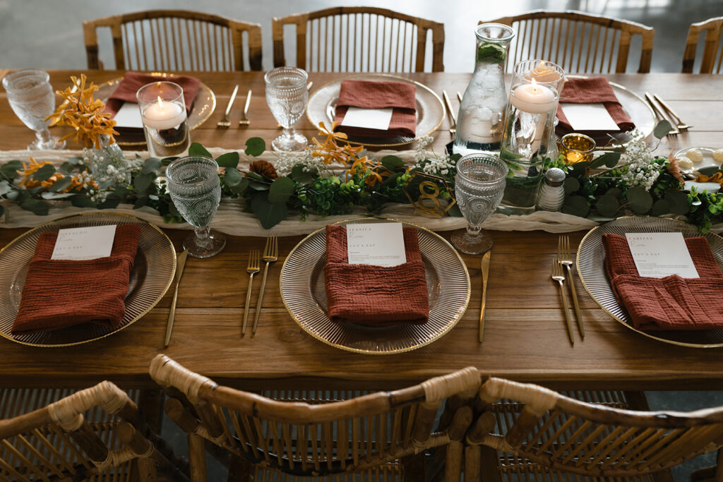 table decor, chargers with gold ware, floating candles and eucalyptus